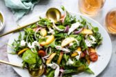 A platter of burrata salad with peaches.