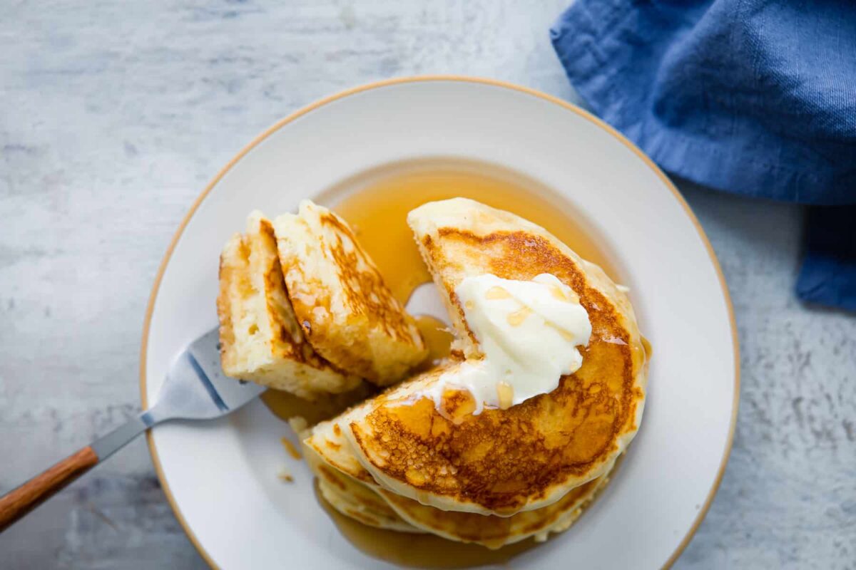 A stack of buttermilk pancakes on a plate.