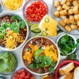 Two bowls of chili on a chili bar.