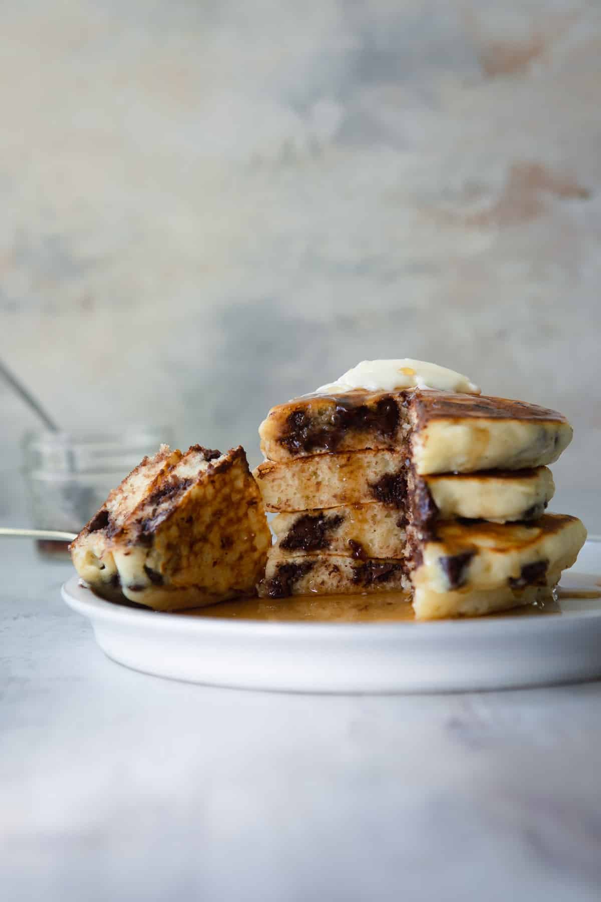 A stack of chocolate chip pancakes on a plate.