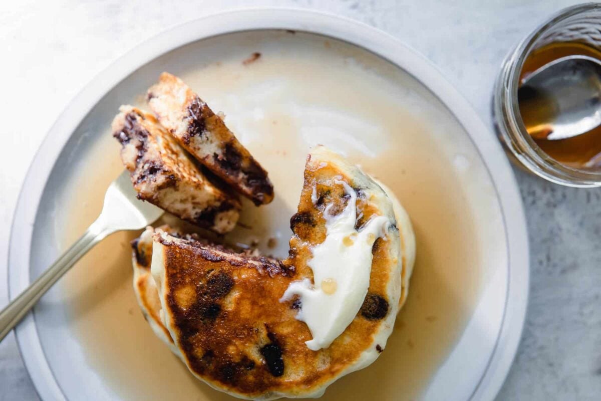 A stack of chocolate chip pancakes on a plate.