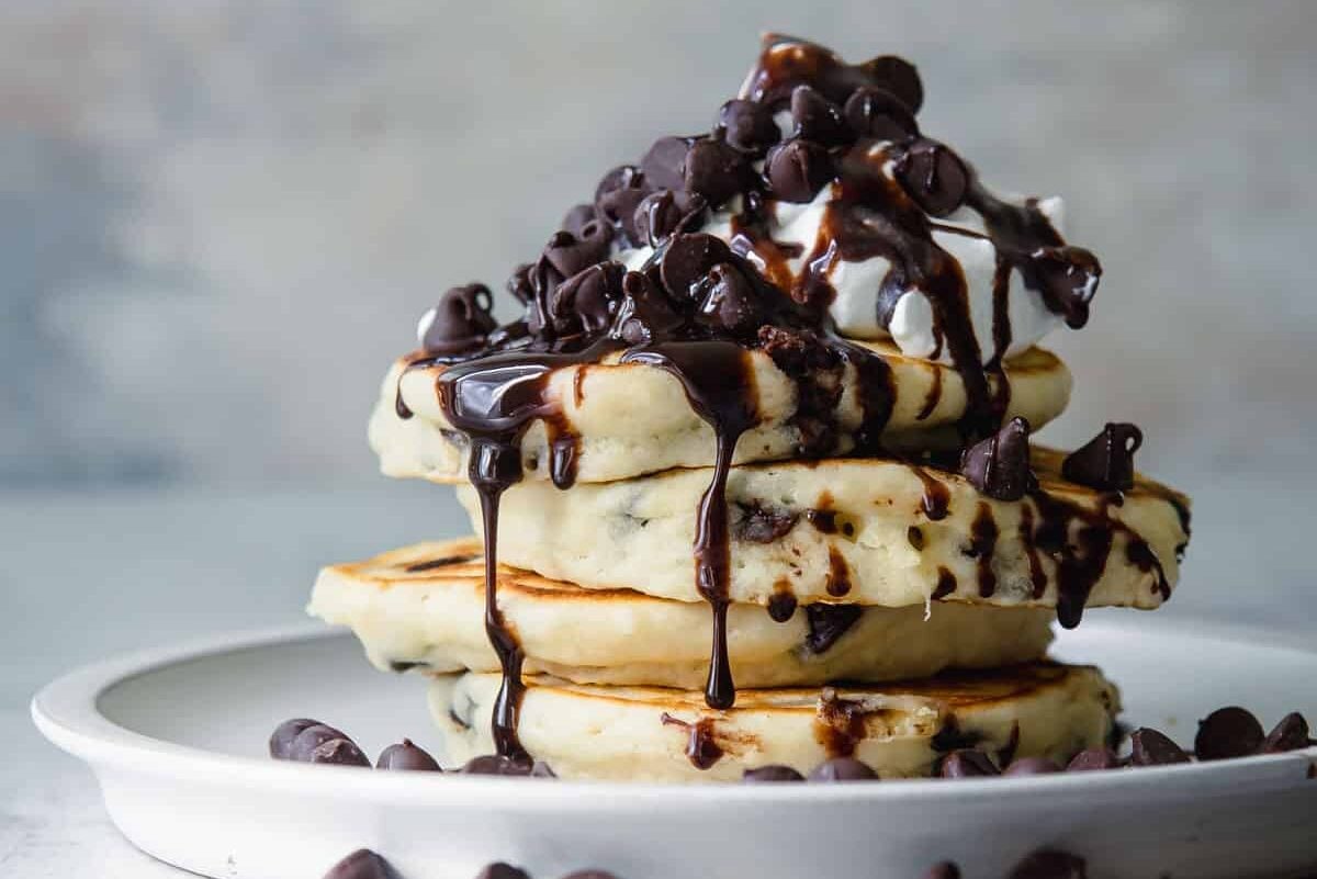 A stack of chocolate chip pancakes on a plate.