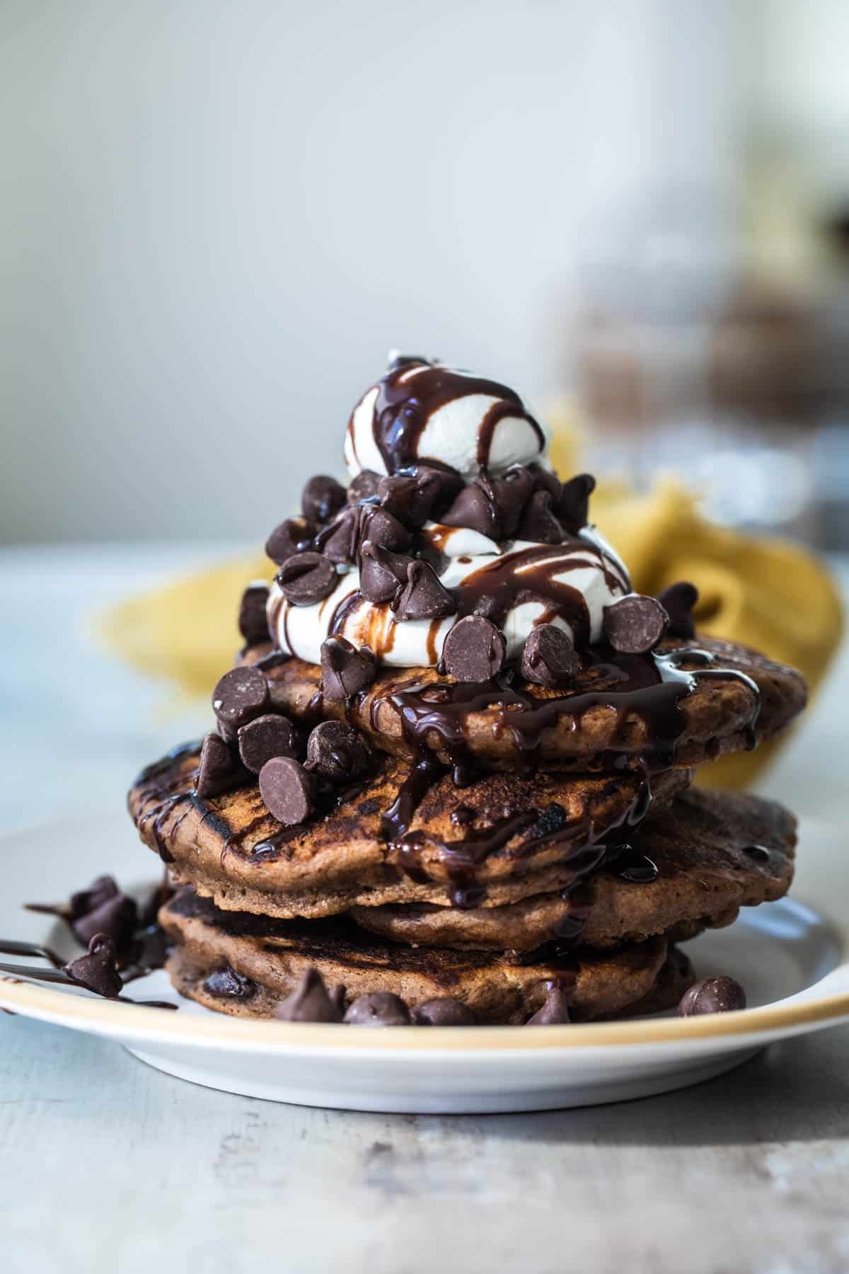 A stack of chocolate pancakes on a plate.