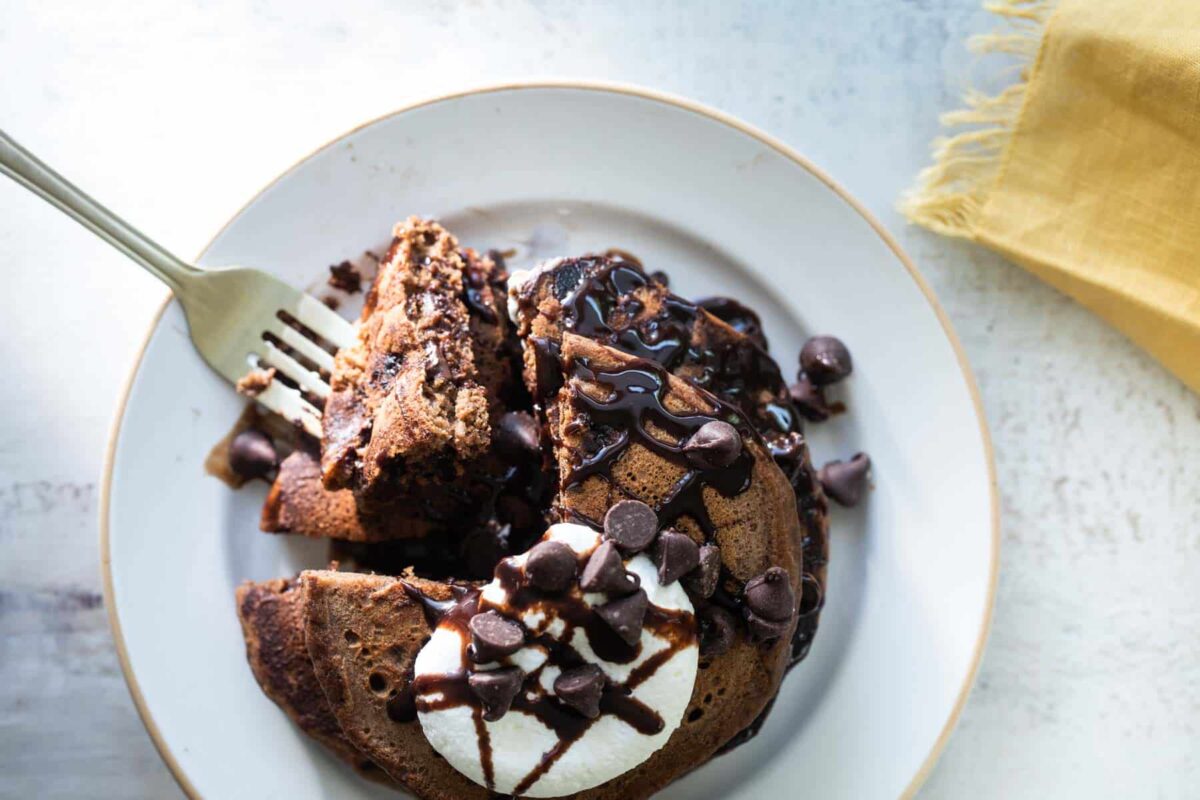 A stack of chocolate pancakes on a plate.
