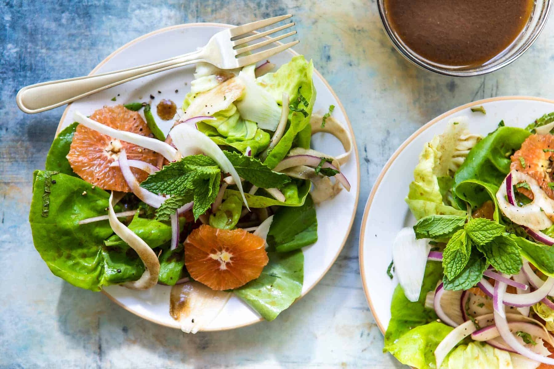 Two fennel salads with oranges on a plates.