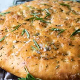 A loaf of focaccia on a cooling rack.