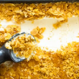 A pan of fried ice cream with an ice cream scoop in it.