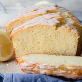 A lemon yogurt cake on a wooden cutting board.