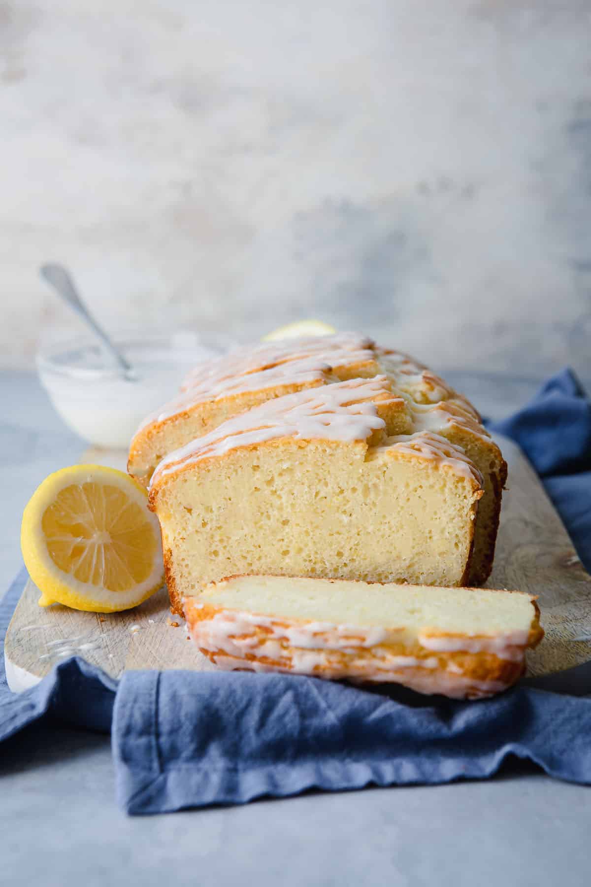A lemon yogurt cake on a wooden cutting board.