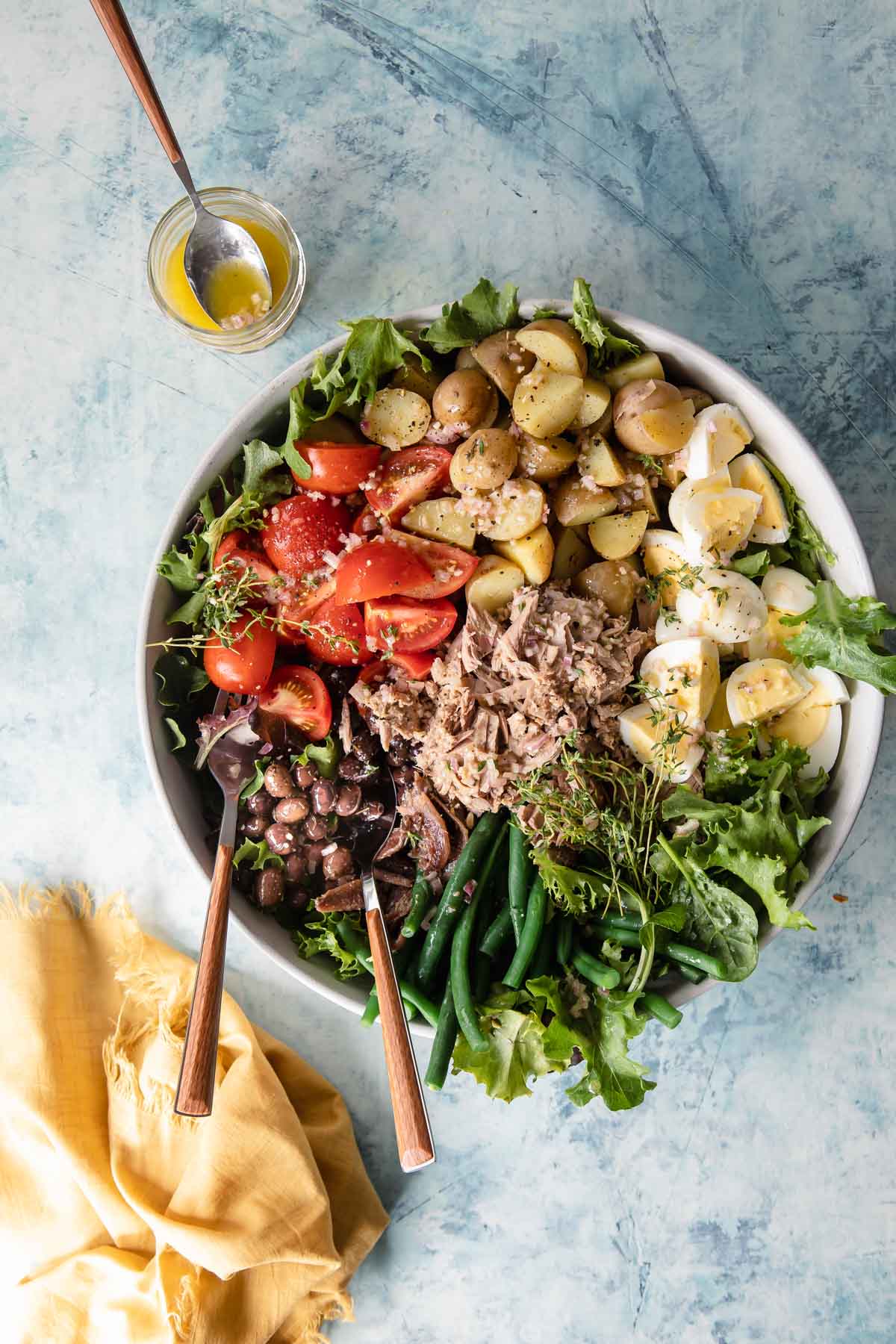 A large serving bowl with Niçoise Salad.