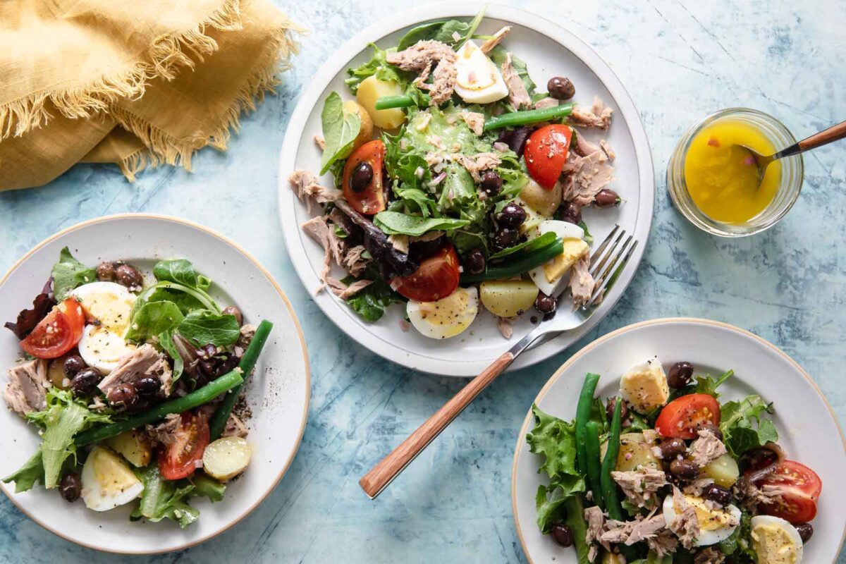 Three plates with Niçoise Salad.