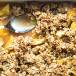 Peach Crisp in a baking dish with a spoon.