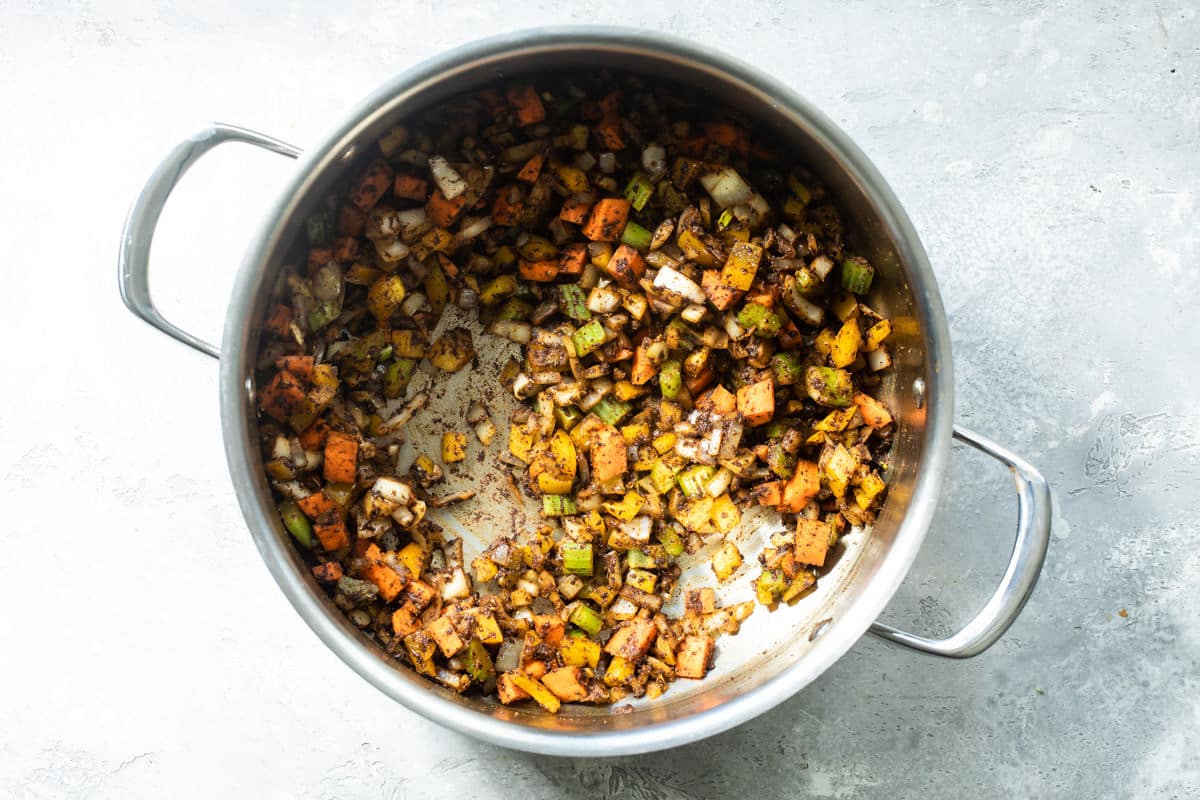 Vegetables and spices cooking in a skillet for chili.