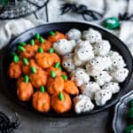 A plate of Halloween walnuts decorated to look like pumpkins and mummies.