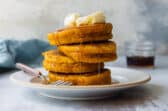 A stack of pumpkin pancakes on a white plate.
