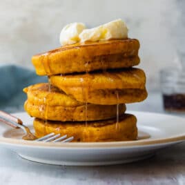 A stack of pumpkin pancakes on a white plate.