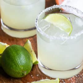 A wooden board with 2 Virgin margaritas on it.
