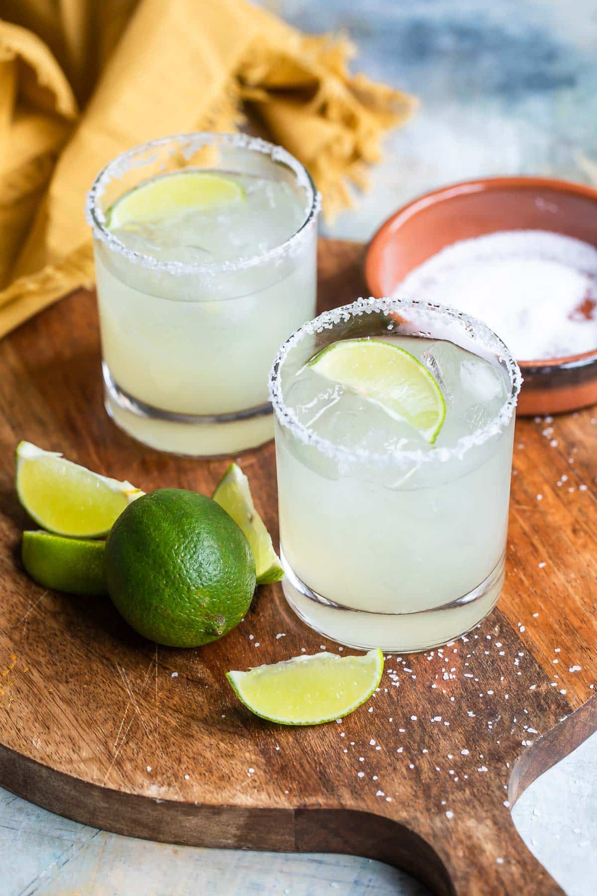 A wooden board with 2 Virgin margaritas on it.