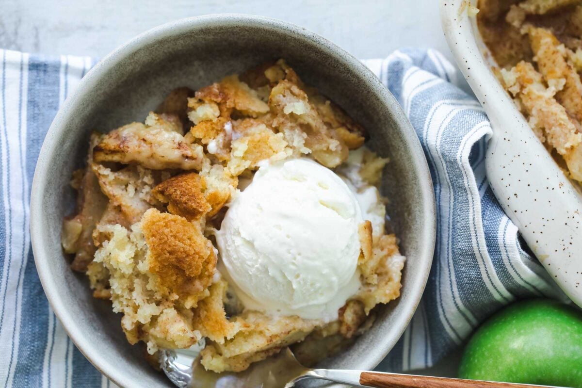 A dish of apple cobbler with ice cream on top.