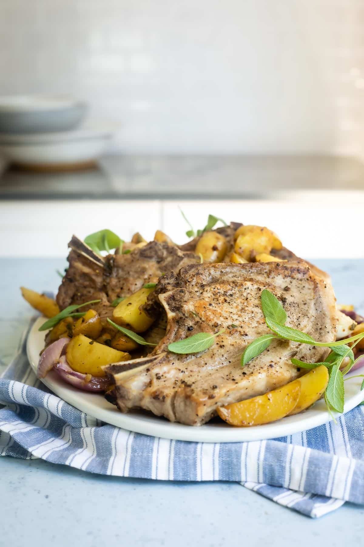 Baked pork chops on a platter with vegetables.