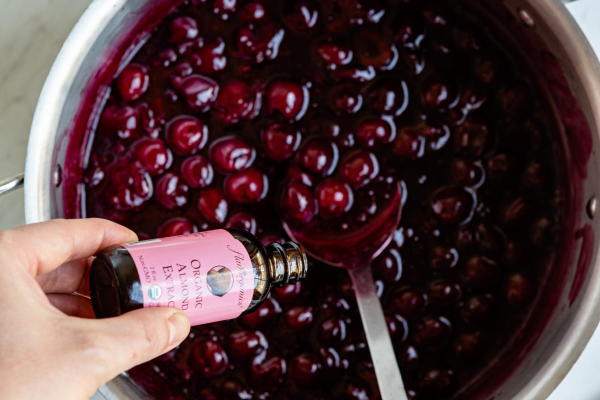 Cooking cherry pie filling in a large stock pot.