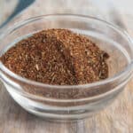 A bowl of homemade chili seasoning on a cutting board.
