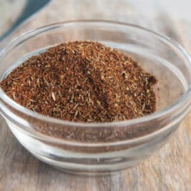 A bowl of homemade chili seasoning on a cutting board.