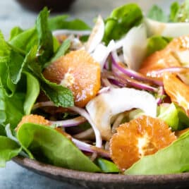 Fennel salad with oranges in a brown bowl.