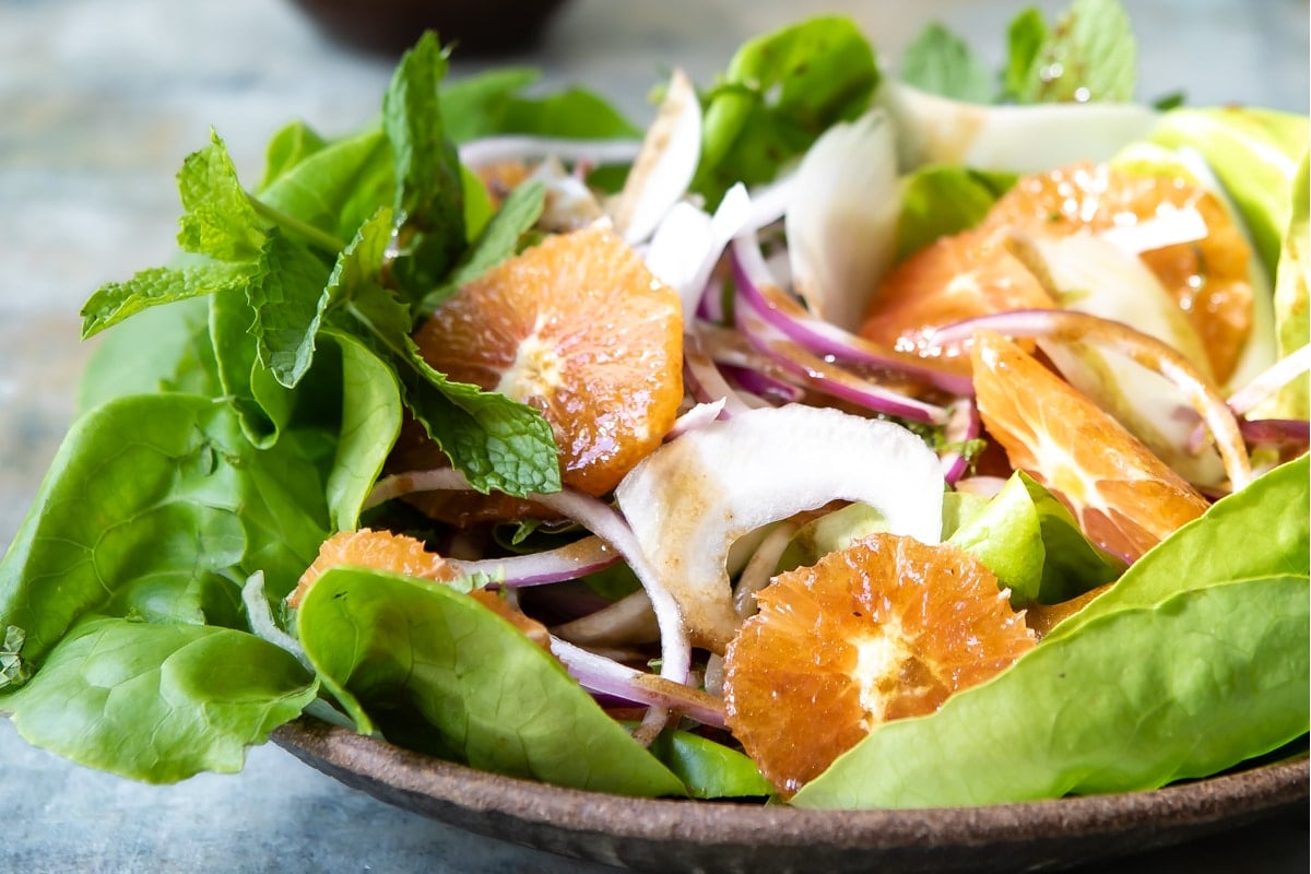 Fennel salad with oranges in a brown bowl.