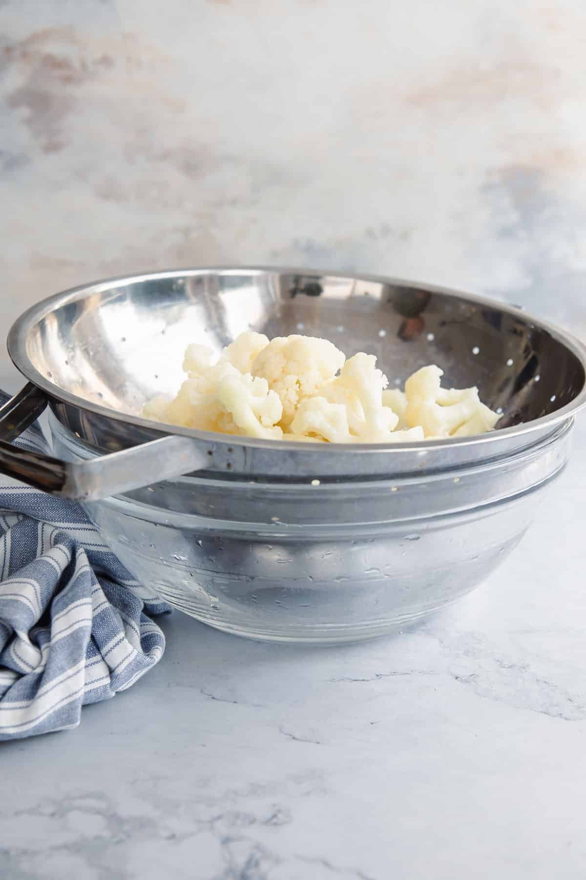 Blanched cauliflower in a colander.