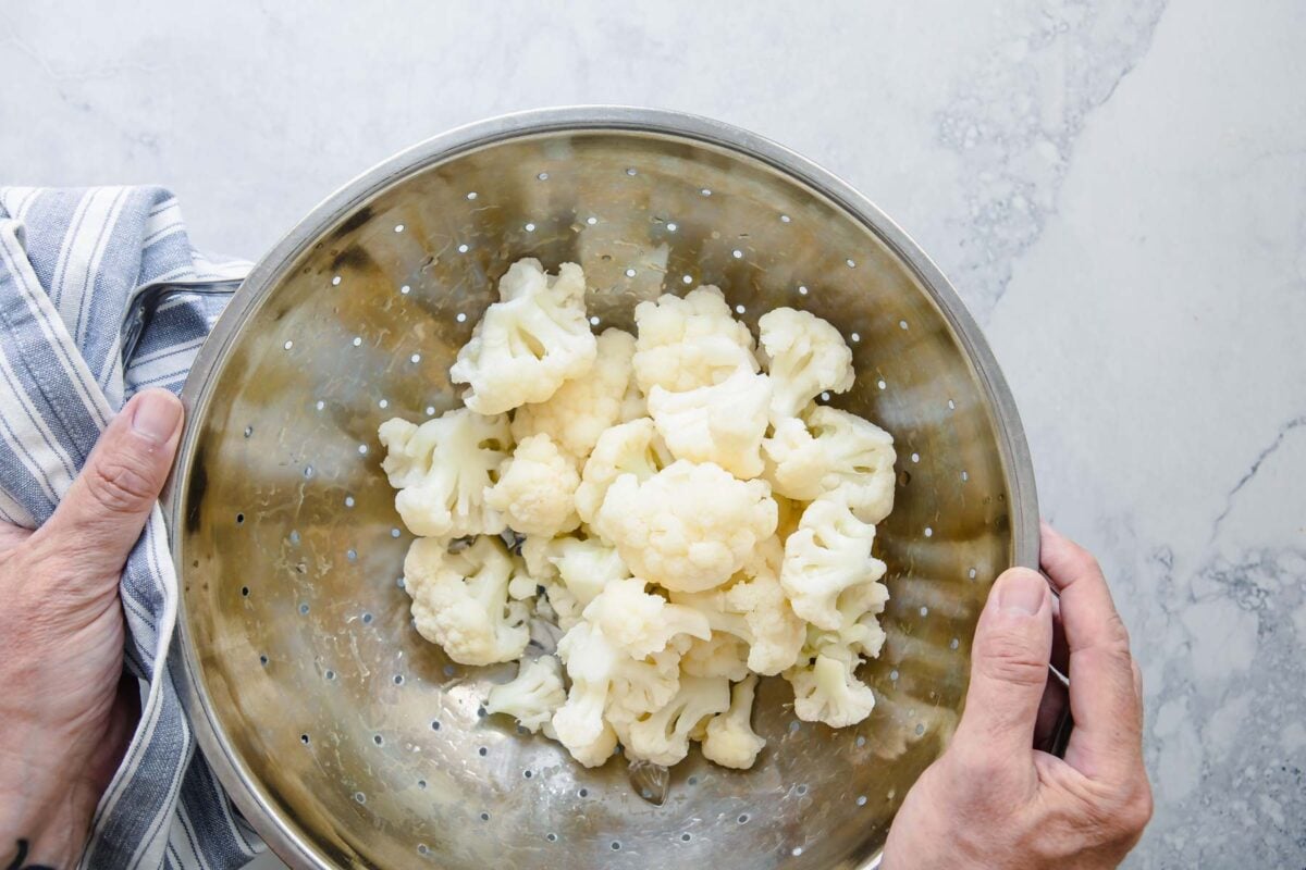 Blanched cauliflower in a colander.