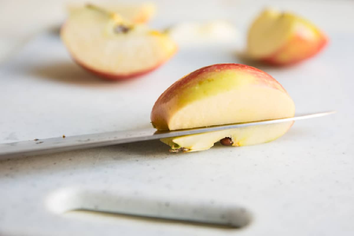 A knife cutting into an apple.