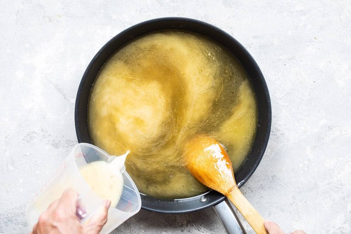 Adding cornstarch to chicken pan drippings to make gravy.