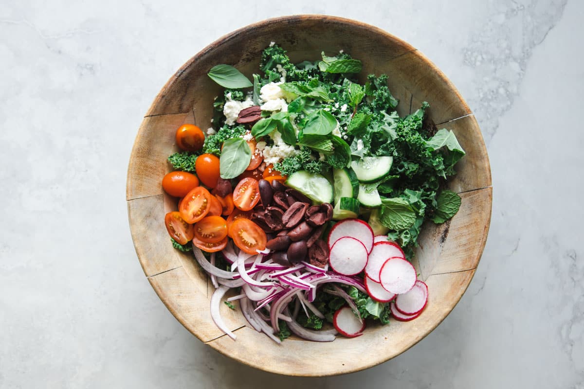 Mediterranean Lentil Salad ingredients in a wooden bowl before adding dressing.