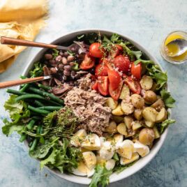 A Nįcoise Salad in a bowl with utensils.