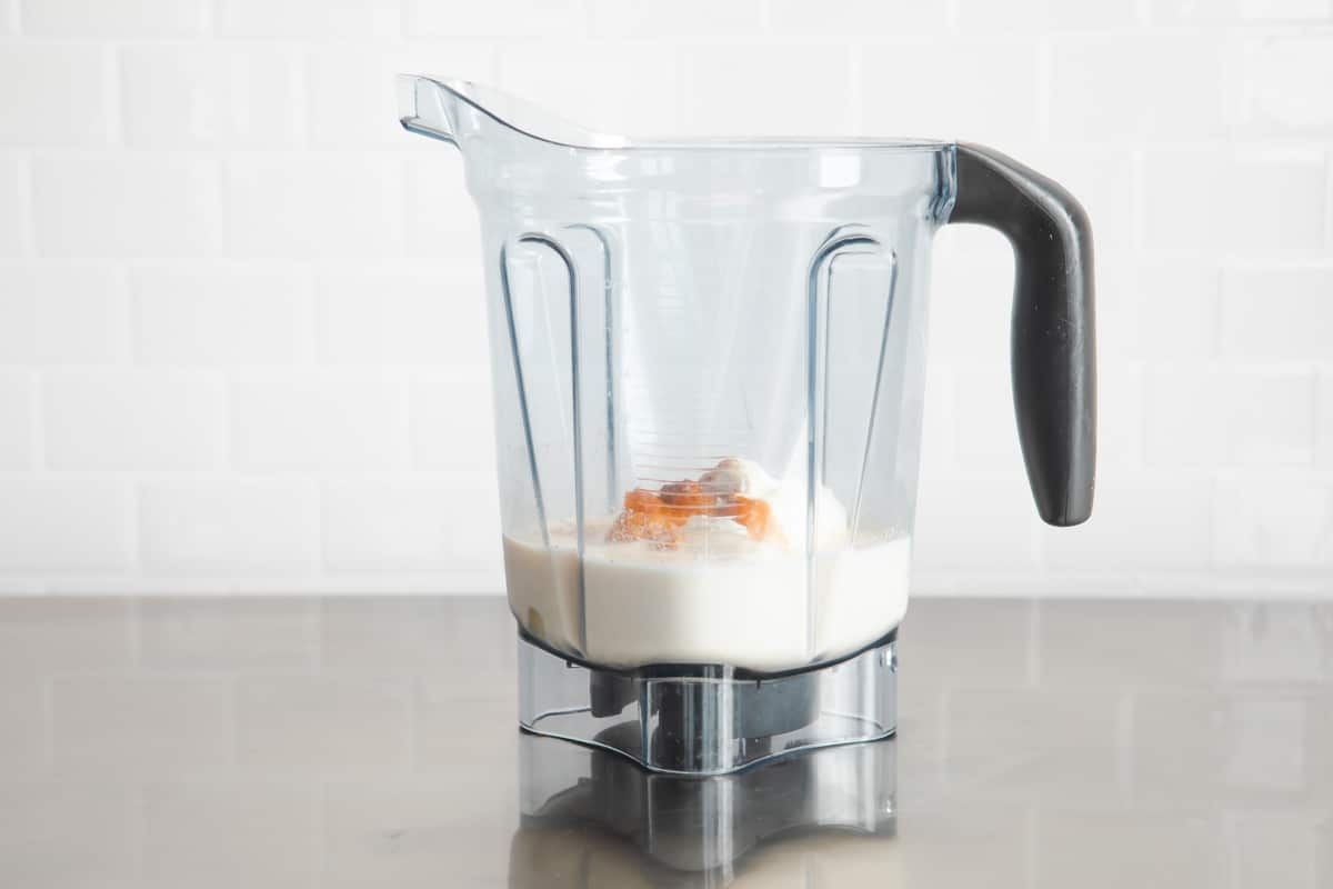 A pumpkin smoothie in a blender before being blended.