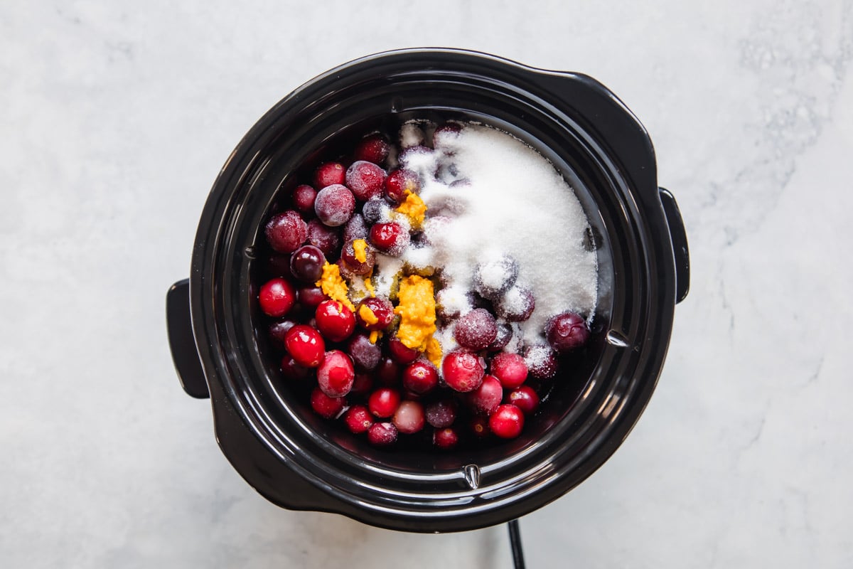 Ingredients in a slow cooker to make cranberry sauce.