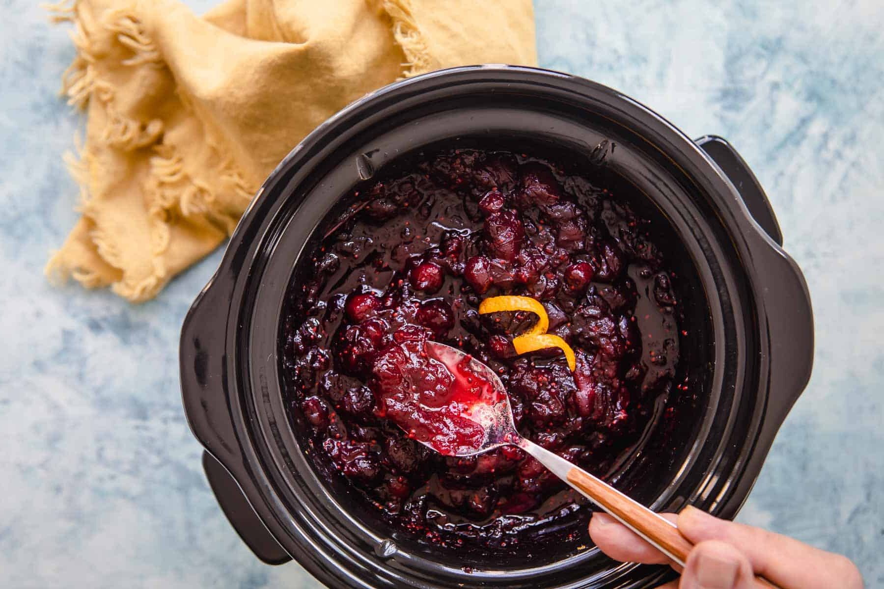 A slow cooker full of cranberry sauce.