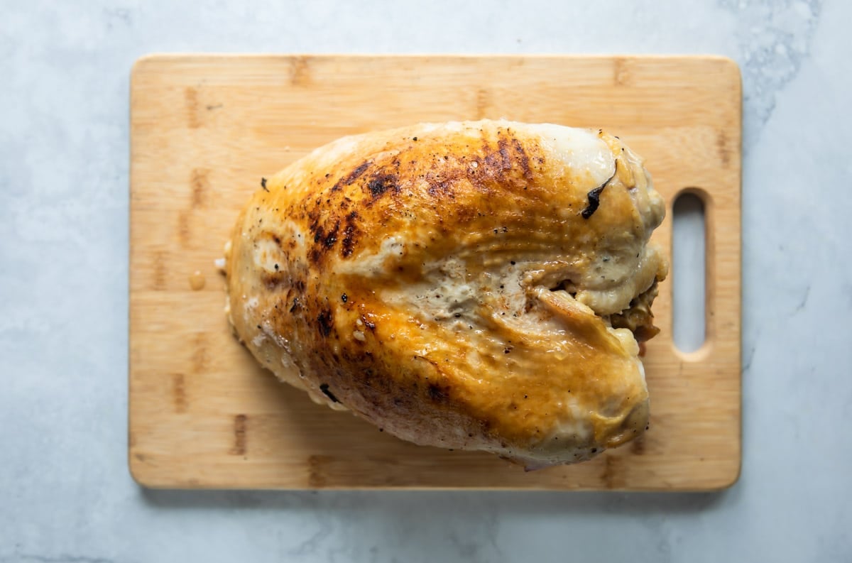 A cooked turkey breast in a crockpot.