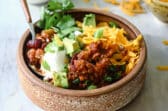 Turkey chili in a small brown bowl.