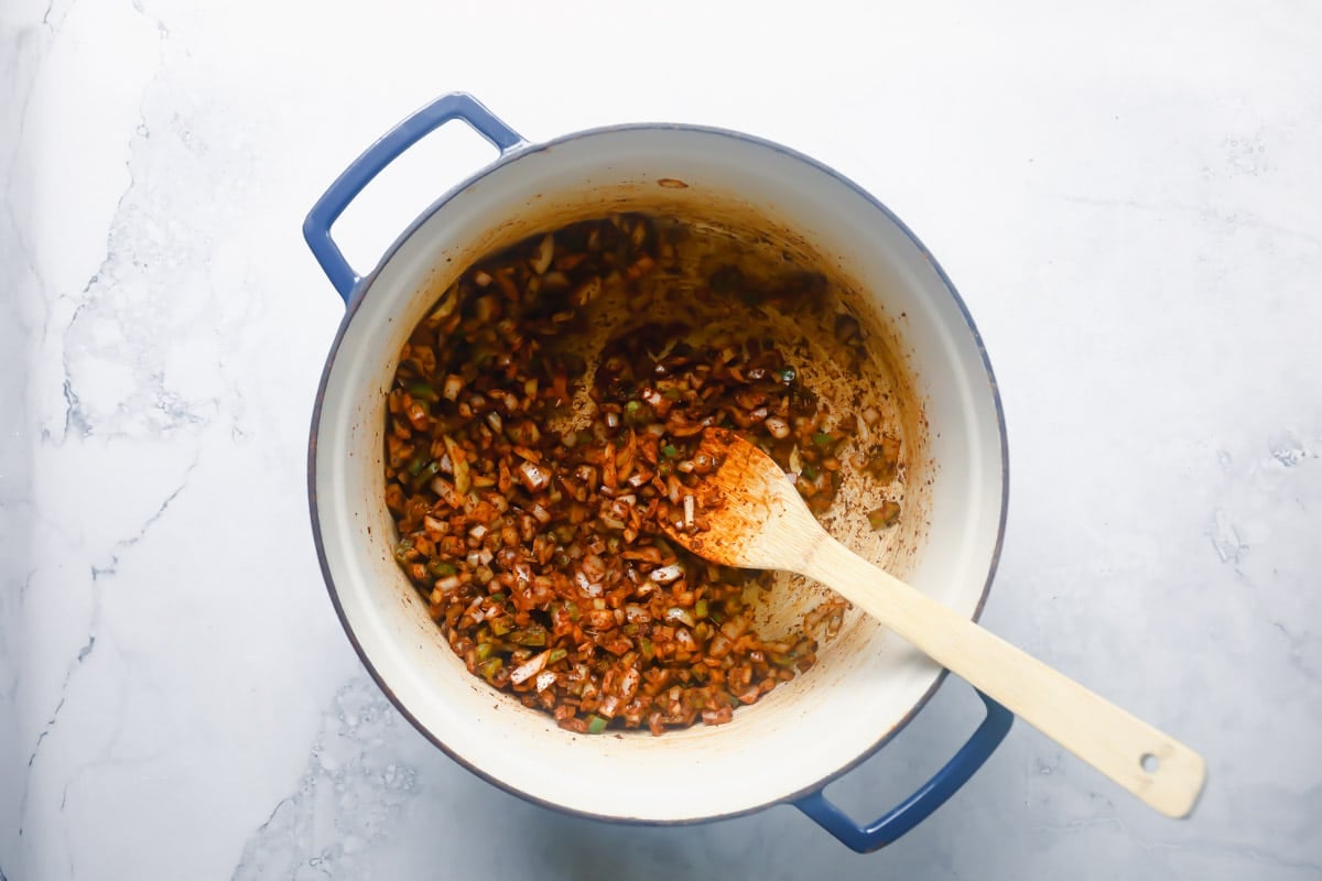 Vegetables and seasoning for turkey chili in a Dutch oven.
