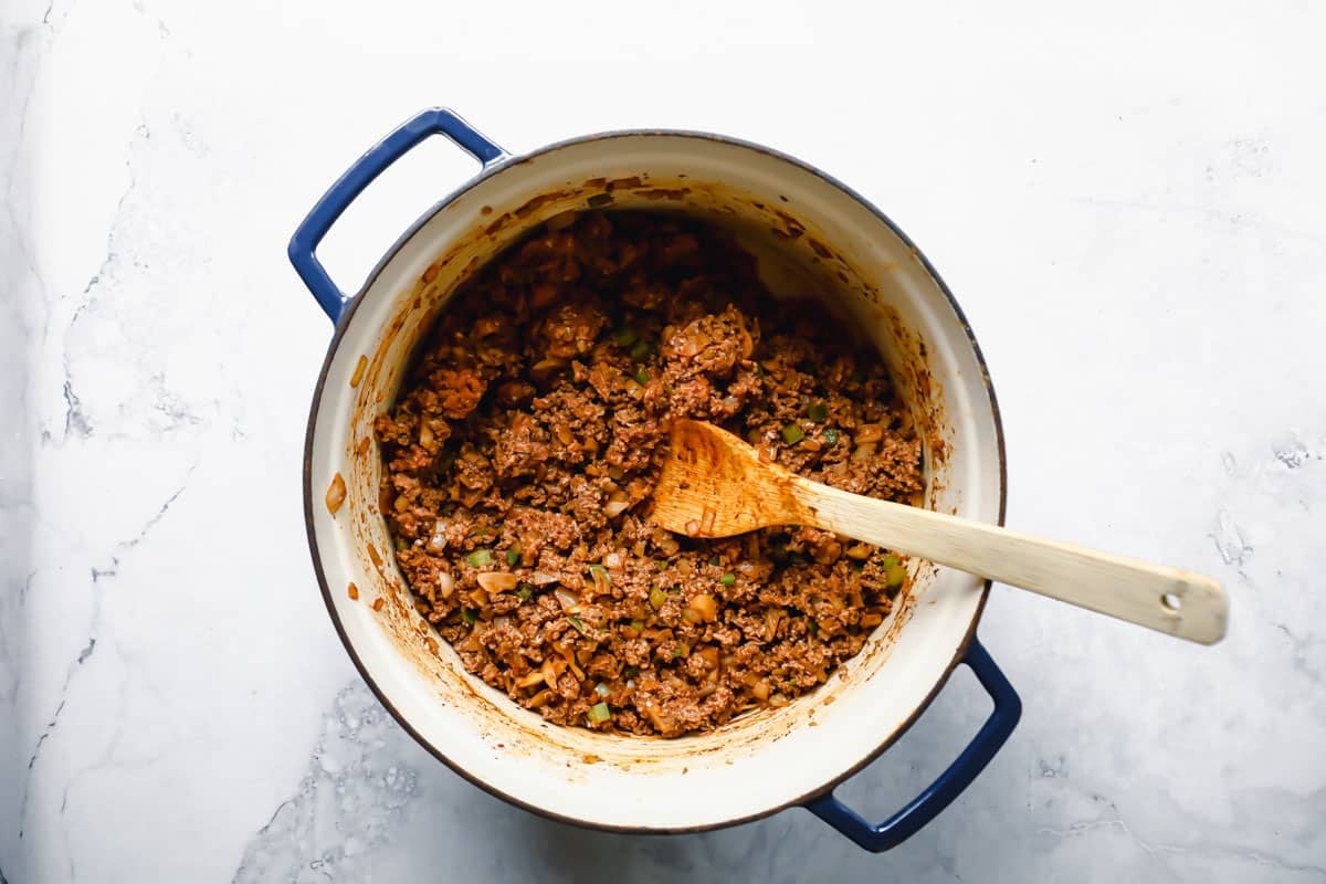 Ground turkey, vegetables and seasoning for turkey chili in a Dutch oven.