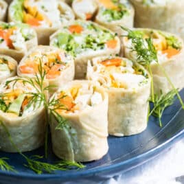 Veggie tortilla roll ups on a blue platter.