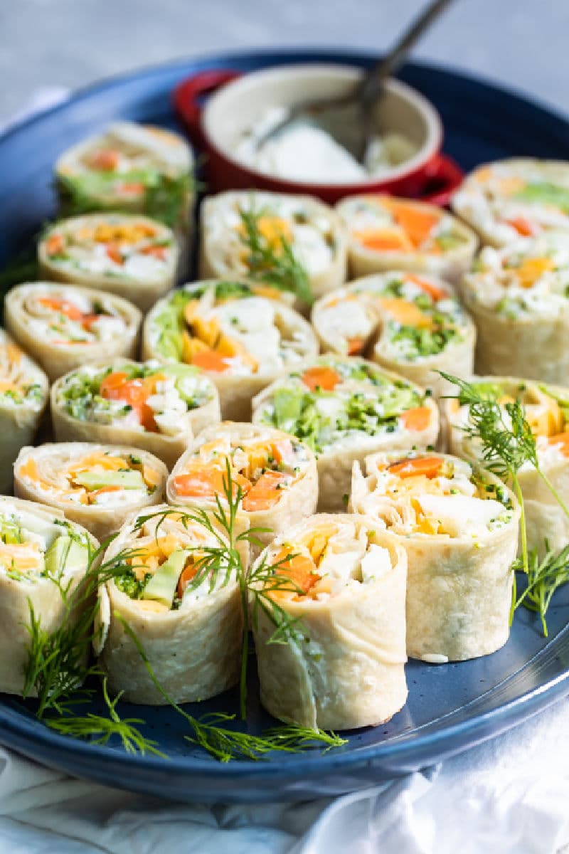 Veggie tortilla roll ups on a blue platter.