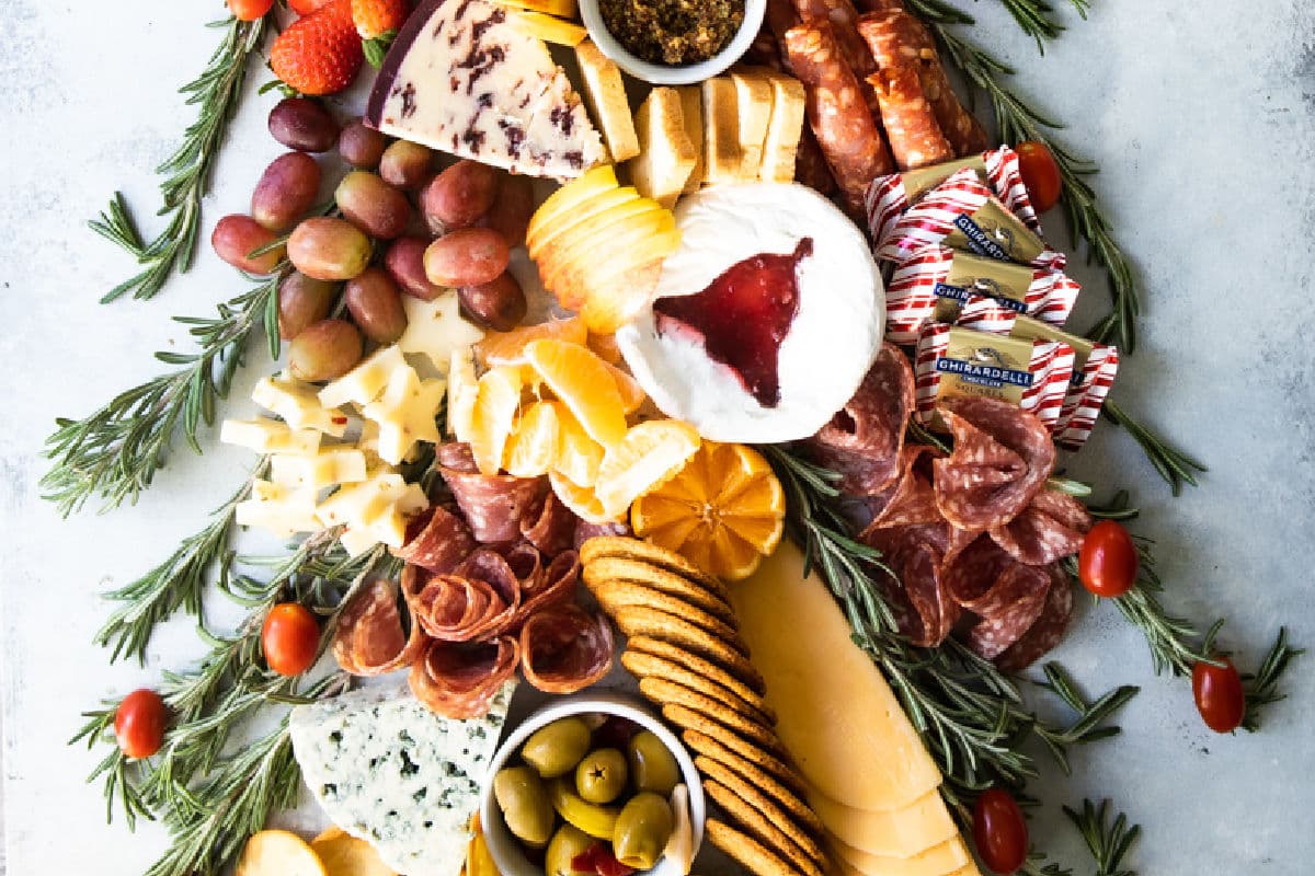 A christmas charcuterie board shaped like a christmas tree.