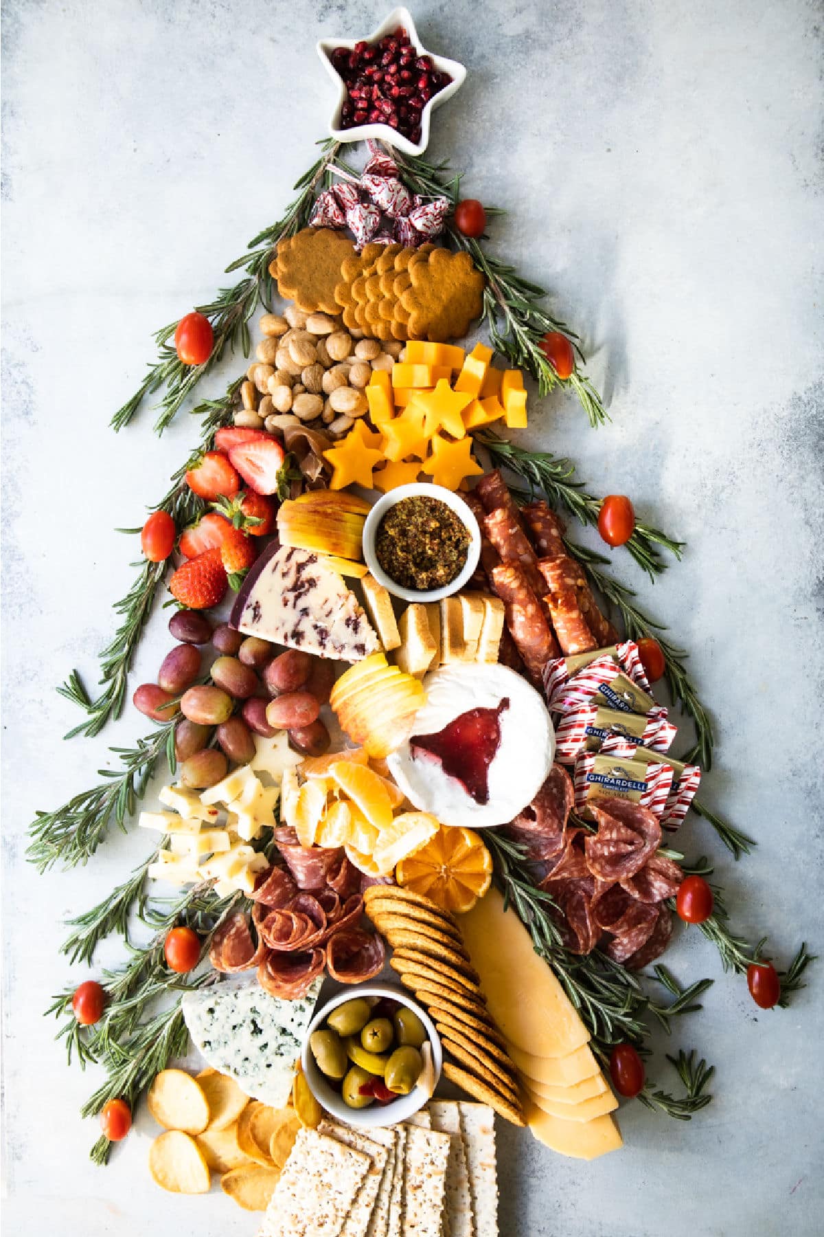 A christmas charcuterie board shaped like a christmas tree.