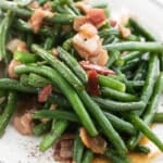 A platter full of green beans and bacon.