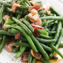 A platter full of green beans and bacon.