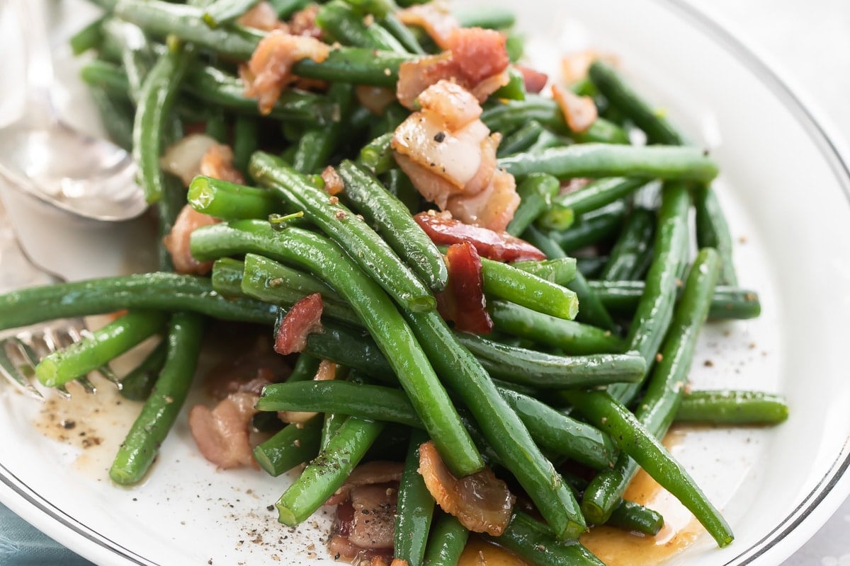 A platter full of green beans and bacon.