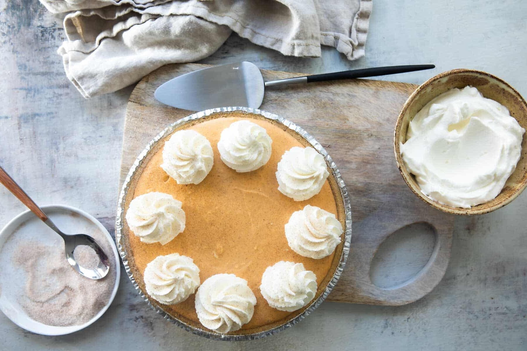 A no-bake pumpkin cheesecake with whipped cream on top.